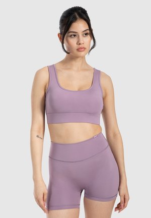 Lilla sømløs sports-bh og shorts sæt med høj talje. Fremstillet af strækbart materiale med en glat tekstur og minimalistisk design.