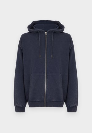 Marineblauer Kapuzenpullover mit Reißverschluss aus weichem Stoff, mit Kapuze, Fronttaschen sowie gerippten Bündchen und Saum. Dezente Textur durchgehend.