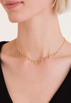 Gouden ketting met verschillende heldere edelstenen, met een delicate ketting en variërende steengroottes, die elegant om de hals valt.