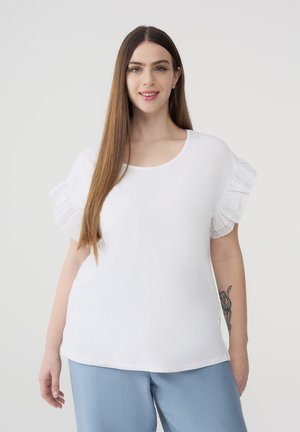 Top bianco a maniche corte con dettagli in chiffon arricciato sulle spalle, scollatura tonda e vestibilità morbida. Indossato con pantaloni blu chiaro.