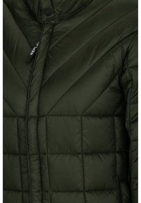 Veste matelassée vert foncé avec des coutures diagonales et horizontales, avec une languette de fermeture éclair avec le texte "REPLAY".