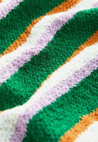 Tissu texturé avec des rayures diagonales en vert, blanc, violet clair et jaune moutarde, présentant un motif de surface bouclé et touffeté.