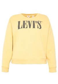 Sudadera amarilla con cuello redondo, puños y dobladillo acanalados. Presenta un destacado logo negro de "LEVI'S" en la parte frontal. Textura de tela suave.