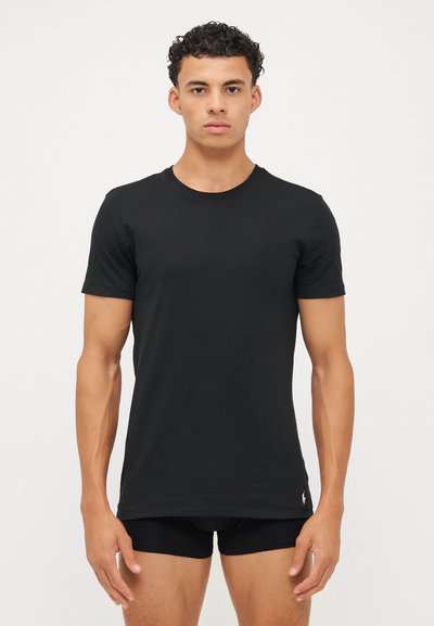 Μαύρο T-shirt με σκουρόχρωμο λαιμόκοψη, κατασκευασμένο από βαμβάκι, κοντά μανίκια, εφαρμοστή σχεδίαση, με μικρό λογότυπο στο αριστερό στρίφωμα. Ιδιαίτερα επίπεδη υφή.