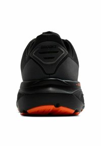 Scarpe da corsa nere con suola arancione. Presentano una tomaia in mesh testurizzato, collare imbottito e logo riflettente sul tallone posteriore.