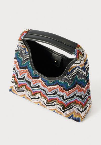 Woven handbag with a zigzag pattern in multicolored threads, featuring a black leather handle and an open top. Textured surface.