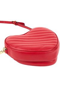 Sac bandoulière en cuir matelassé rouge en forme de cœur avec une bandoulière réglable et des ferrures dorées.