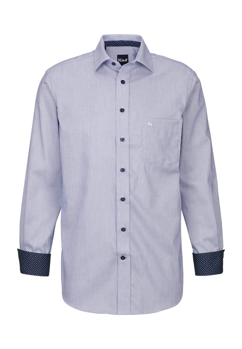 Camicia blu chiaro con bottoni, a righe verticali, maniche lunghe e taschino sul petto. I polsini presentano un motivo a pois di colore blu scuro.