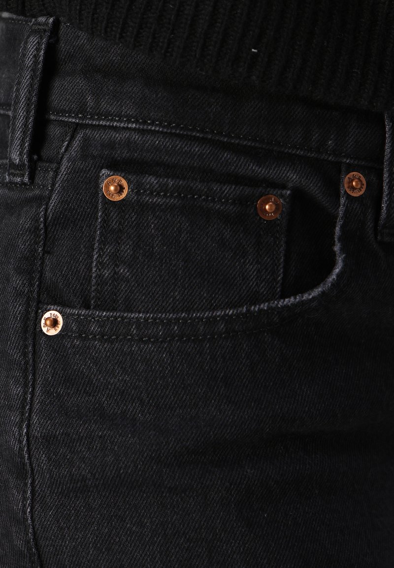 Schwarze Jeans aus Denim mit glatter Textur, ausgestattet mit Kupferrivets, Fünf-Taschen-Design und einer taillierten Silhouette. Keine sichtbaren Markenkennzeichnungen.