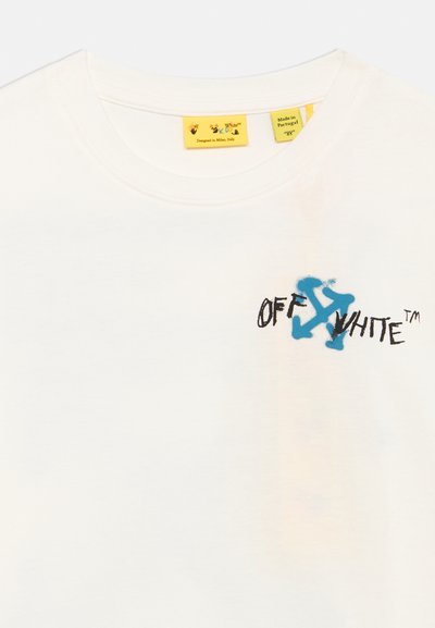Λευκό T-shirt με στρογγυλή λαιμόκοψη, με μπλε λογότυπο Off-White και μαύρο χειρόγραφο κείμενο "OFF WHITE™" στο στήθος, και κίτρινες ετικέτες ρούχων στο εσωτερικό του λαιμού.
