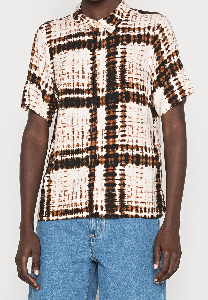 Chemise à manches courtes en tissu léger avec un motif tie-dye abstrait dans des tons de beige, marron et noir, dotée d'un col.