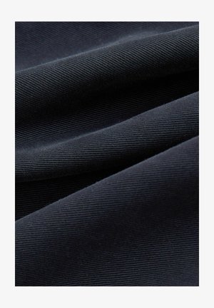 Donker marineblauwe stof met fijne diagonale ribbels, zacht gevouwen om de textuur- en weefdetails te benadrukken.