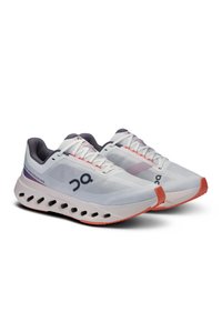 Weiße Laufschuhe mit einem leichten Mesh-Obermaterial, lila und korallenfarbigen Akzenten, gepolsterter Sohle mit Ausschnitten und flachen Schnürsenkeln.