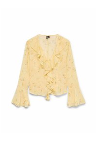 Blouse jaune avec un devant à volants, des manches longues en forme de cloche et un motif floral avec des accents verts. Tissu léger et semi-transparent.