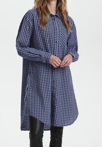 Blue and white checkered shirt dress with a button-down front, long sleeves, and a single chest pocket. Made of lightweight fabric.