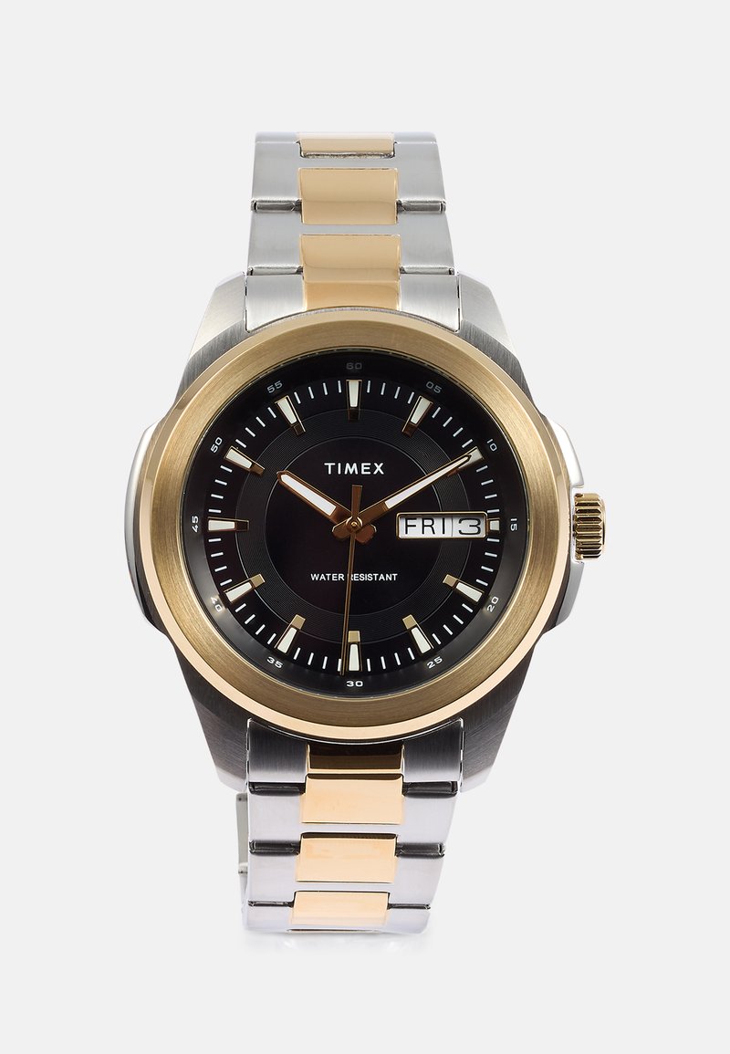 Zegarek Timex z czarną tarczą, złotą obręczą, metalowym paskiem w srebrnym i złotym kolorze oraz wyświetlaczem daty; podkreślona funkcja wodoszczelności.