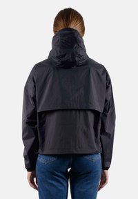 Giacca leggera nera con cappuccio, vestibilità comoda e design posteriore a strati. Presenta polsini elastici e una texture liscia e impermeabile.
