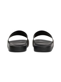 Chinelas de plástico pretas com sola plana e duas largas tiras abertas. Textura lisa com detalhes mínimos e bordas arredondadas.