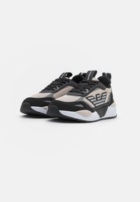 Zwarte en beige sport schoenen van mesh en synthetische materialen. Heeft een geprofileerde zool, vetersluiting en logo accenten.