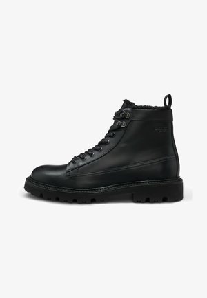 Black leather ankle boot with a textured finish, lace-up front, and rugged sole. Features faux fur lining and a pull tab at the back.