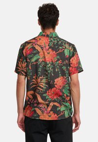 Kurzarmshirt mit schwarzem Hintergrund, verziert mit leuchtenden orangefarbenen, roten und grünen Blumenmustern; aus leichtem Stoff mit lockerer Passform.