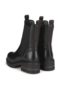 Melnas zamšādas potīšu zābaki ar elastīgām sānu malām, biezām zoles un brūnu šuvju akcentiem aizmugurē. Virsma ir gluda un izsmalcināta.