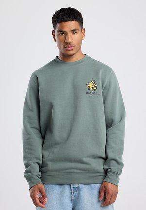 Sudadera verde hecha de una mezcla de algodón, con cuello redondo, mangas largas y un logotipo gráfico amarillo en el pecho.