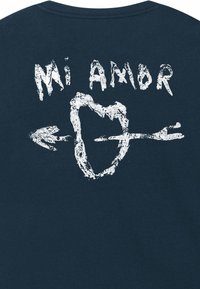 T-shirt in cotone blu scuro con testo bianco disegnato a mano "Mi Amor" sopra un cuore con un design di freccia, enfatizzando uno stile artistico e testurizzato.