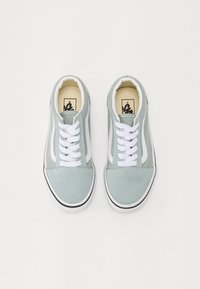 Sneakers in suede verde chiaro con dettagli e lacci bianchi, dotati di una striscia laterale bianca, punta rotonda e suola in gomma nera.