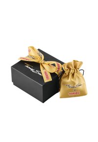 Scatola nera con una sacca di raso dorata con coulisse attaccata. La scatola presenta un logo e un nastro giallo con la scritta "Haribo" in rosso.