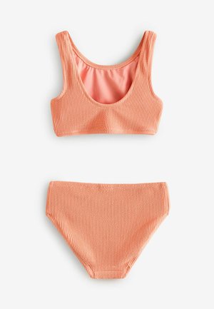 Persikofärgad stickad bikiniuppsättning med skärning i halsen och matchande högmidjade underdelar. Texturerad tyg med slät inre foder.