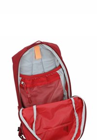 Zaino rosso con interno grigio. Dotato di una tasca in rete, un'etichetta arancione e un compartimento con zip. Tessuto morbido con una forma strutturata.