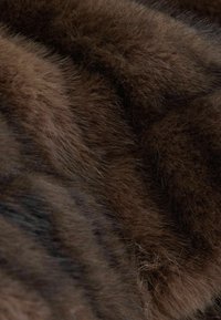 Faux fur fabric in various shades of brown, featuring long, soft fibers with subtle striping and a dense, textured appearance.