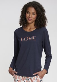 Marinblå långärmad T-shirt i bomull med tryckt text "ÄLSKA dig själv" i ljusrosa. Rund halsringning och avslappnad passform.