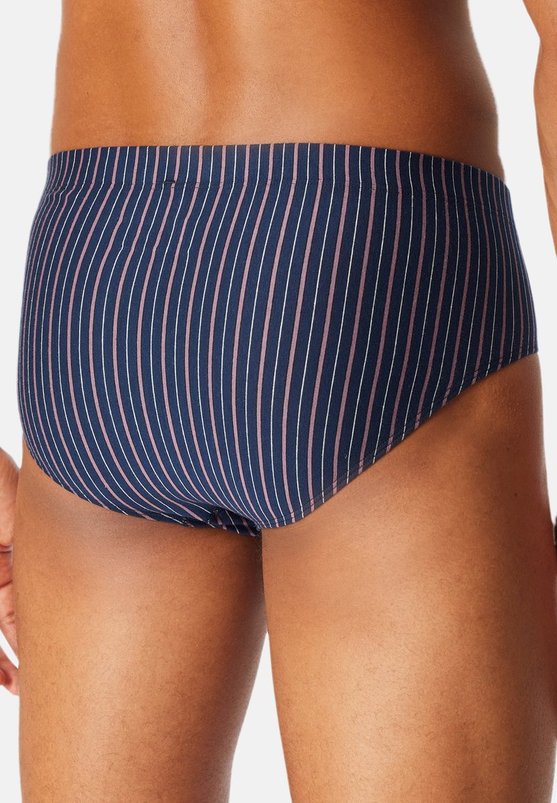 Marineblaue Schwimmslips mit vertikalen Streifen in Pink. Aus einem dehnbaren Stoff gefertigt, mit einem tief sitzenden Schnitt und elastischem Bund. Rückansicht gezeigt.