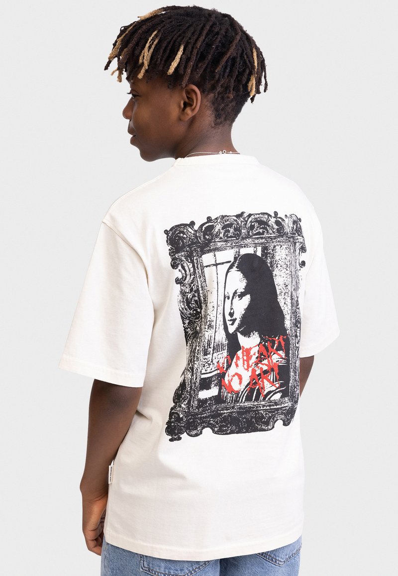 T-shirt en coton crème avec un imprimé noir et blanc de la Joconde encadré de détails ornés et de texte rouge. Manches courtes, coupe ample.