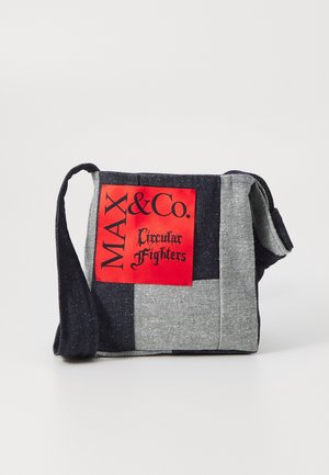 Sac bandoulière patchwork en denim avec une large sangle et une étiquette rouge portant l'inscription "MAX&Co. Circular Fighters" en texte noir.