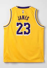 Žlutý basketbalový dres s fialovými a bílými detaily, na zadní straně s nápisem "JAMES" a číslem "23", s logem NBA na výstřihu.