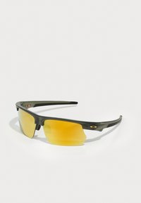 Sportsonnenbrille mit einem mattschwarzen Rahmen, gelb getönten Gläsern und einem schlanken Design. Verfügt über ein Logo-Detail am Bügel.
