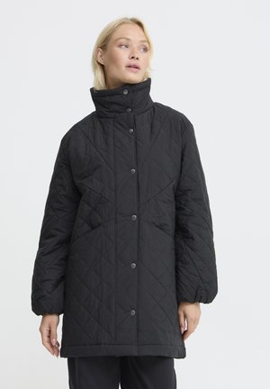 Schwarze gesteppte Jacke mit hohem Kragen, Druckknöpfen und lockerer Passform. Der Stoff hat ein strukturiertes, diamantähnliches Muster. Lange Ärmel mit elastischen Bündchen.