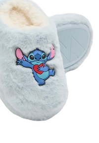 Lyseblå, fluffy bløde tøfler med en plysforing, der har et broderet tegneseriefigurdesign på siden. Tekstureret gummisål.