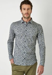 Hemd mit Knopfleiste, das ein navyblaues und cremefarbenes Blattmuster aufweist, lange Ärmel und einen klassischen Kragen hat, aus leichtem Stoff gefertigt.