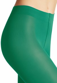 Collant verdi trasparenti con una texture liscia, design a vita alta e un delicato motivo a costine, che mettono in evidenza una silhouette aderente.