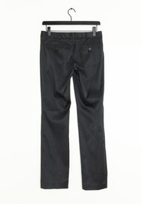 Pantalons rayés gris foncé avec deux poches arrière, texture lisse et coupe droite, suspendus à un cintre en métal noir.