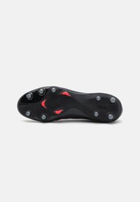 Schwarze Fußballschuhsohle mit sechs Stollen, roten Akzenten, strukturierten Oberflächen und "COPA"-Branding. Robuste Gummikonstruktion für Traktion.