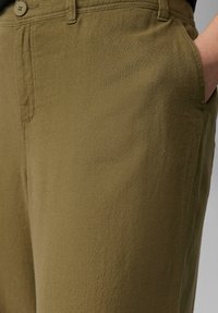 Olijfgroene, lichtgewicht broek met een soepele textuur, voorzien van zijzakken en een knoopsluiting op de taille.