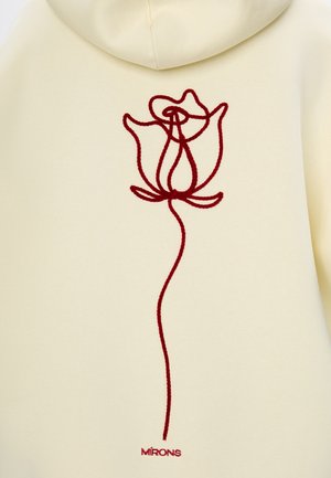 Kremowa bluza z kapturem z czerwonym haftowanym wzorem róży z tyłu, o gładkiej teksturze i regulowanym kapturze. Podkreślona metką marki.