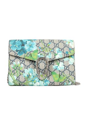 Petit sac rectangulaire Gucci avec motif floral bleu, fond beige avec impression du logo GG et fermoir argenté en forme de deux têtes d’animaux.