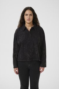 Svart langermet polo-skjorte med teksturert overflate, krage, tre knappelukking og en avslappet passform. Brukt med mørke jeans.