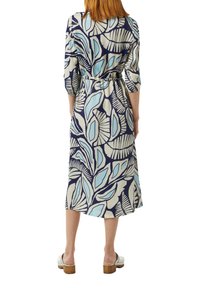 Langärmliges Kleid mit navy Grundfarbe, das mit einem hellblauen und cremefarbenen Blumenmuster verziert ist. Es hat eine taillierte Taille und endet in Knielänge.